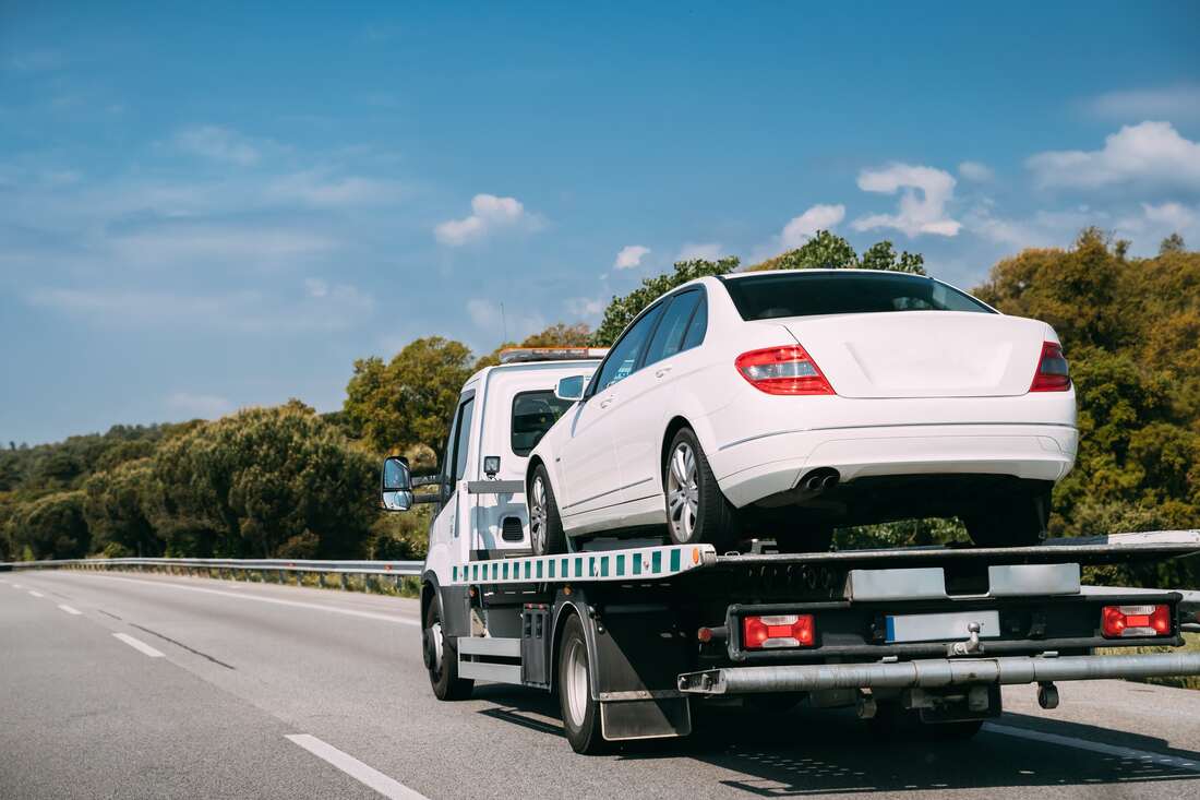 Flatbed Tow Truck carrying white car