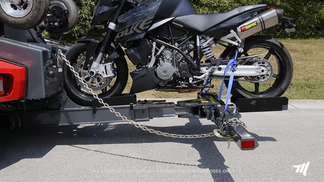 Motorcycle being towed by red tow truck with special motorcycle towing bracket